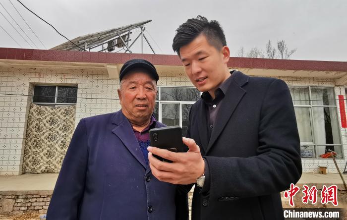 圖為工作人員知道村民李生明使用智慧能源管理平臺。　顏金梅 攝