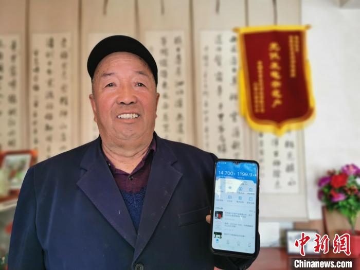 圖為村民李生明展示自家光伏電站發電情況。　顏金梅 攝