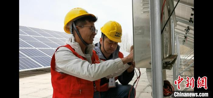 圖為光伏公司技術員檢查維修光伏電站?！☆伣鹈?攝
